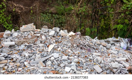Close-up view of concrete rubble, bricks and small pieces of wood that have been demolished from old blooms and dumped near the bushes that are common in rural Thailand.