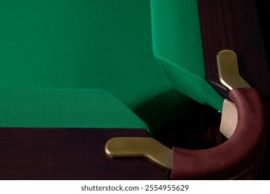 A CloseUp View of a Corner of a Billiards Pool Table Featuring Green Felt and Elegant Brass Details - Powered by Shutterstock