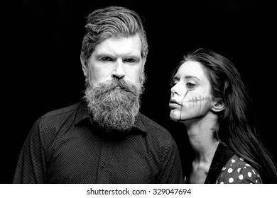 Closeup View Of Couple Of Painted Halloween Holy Chracters Woman And Man With Long Lush Beard Looking Forward On Studio Wall Background Black And White, Horizontal Picture