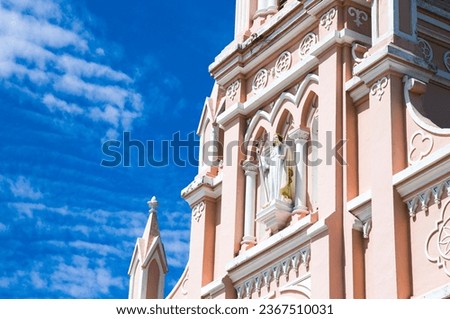 A closeup view of the Da Nang Cathedral also known as Pink Church against a blue sky