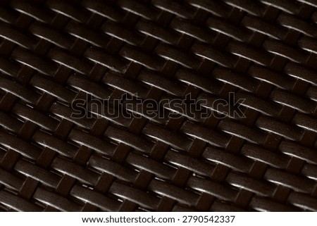 Close-up view of dark elegant wickerwork surface texture for design background.
