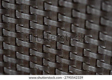 Close-up view of dark elegant wickerwork surface texture for design background.