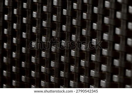 Close-up view of dark elegant wickerwork surface texture for design background.