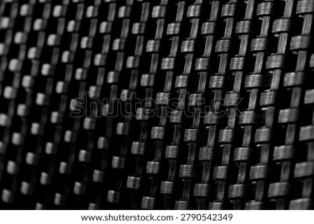 Close-up view of dark elegant wickerwork surface texture for design background.