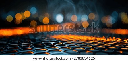 A close-up view of a dark, hexagonal textured surface with reflections of blurry, out-of-focus city lights in orange and blue hues.