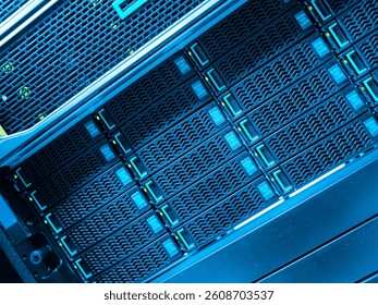 Close-up view of a data center server rack showcasing high-tech storage units. The blue lighting highlights the advanced technology used for data processing.