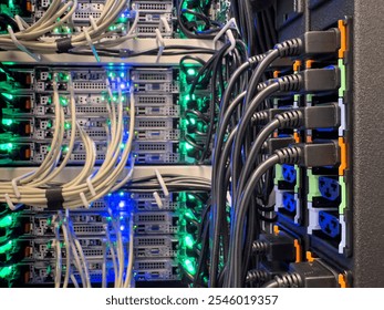 Close-up view of a densely packed server rack. Many beige cables snake between multiple rows of servers. Bright blue and green lights illuminate the internal components. - Powered by Shutterstock