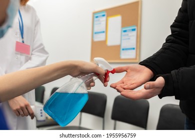 Close-up view of disinfecting the male hands of patients entering a clinic, performed by medical staff in the face of a pandemic - Powered by Shutterstock