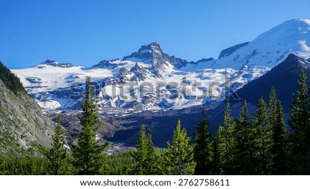 Close-up view of dramatic, glaciated mountain peaks under a clear blue sky in Mount Rainier National Park.