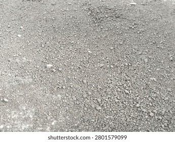 Close-up view of dry soil texture with small gravel and natural earthy pattern. Detailed ground surface background featuring rough dirt particles, suitable for construction, agriculture, geology, environmental concepts, and natural texture designs.