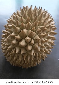Close-up view of a durian fruit shell displaying sharp spikes and natural geometric texture