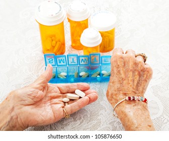 Closeup view of an eighty year old senior woman's hands as she sorts her prescription medicine.