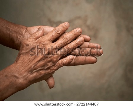 Close-up view of elderly hands gently resting together. A powerful symbol of aging, life experience, care, vulnerability, and the passage of time.