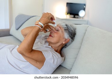 Closeup View At An Elderly Women Using A Bottle Of Eyedrops Due To Ophthalmic Problems. An Older Woman Using Eye Drops For Better Vision. A Senior Woman Is Dropping Liquid In Her Eye With Eye-dropper.