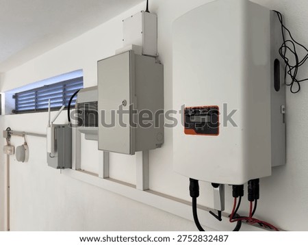 Close-up view of an electrical panel with various circuit breakers and meters, suggesting industrial or commercial electrical infrastructure. Sunlight strea...