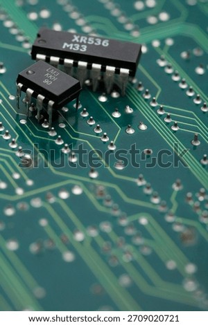 Close-up view of electronic components on a green circuit board with intricate details of connections