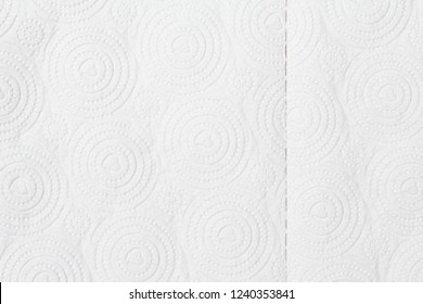 Closeup view of embossed surface texture of new white paper towel tissue from roll in heart-shape, dots, dashed and circular pattern. For wallpaper, backdrop and background with copy space