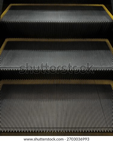 Close-up view of escalator steps featuring metallic grooves and yellow safety edges.