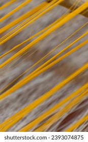 A close-up view of the essential materials of the textile industry: yarn, dye, and wood. The yarn, made from a variety of fibers, is the foundation of all textile products. The dye, a rainbow of color