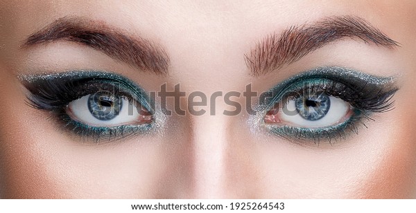 Close-up view of the eyes of a young girl with\
beautiful makeup