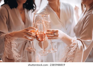 Close-up view of female hands holding glasses with vine or champagne. Bridesmaids and bride celebrate Wedding day  - Powered by Shutterstock