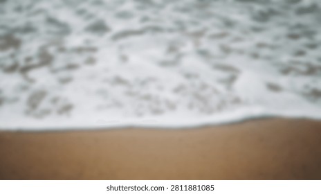 Close-up view of foamy ocean waves gently rolling onto a sandy beach, creating a serene and natural scene.