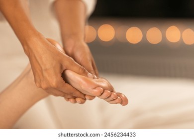 A close-up view of a foot massage in progress, highlighting the skilled hands of the therapist as they apply pressure to the clients foot. - Powered by Shutterstock