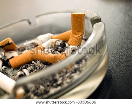 Closeup view of full ashtray on the table.