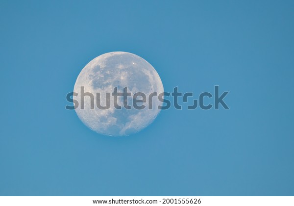closeup view of full moon\
and blue sky