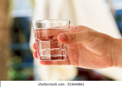 Close-up view of glass of water in male hand