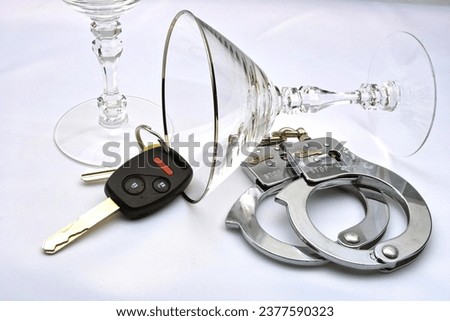 A close-up view of glasses, handcuffs, and a car key.