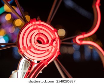 Close-up view of a glowing red neon sculpture at night. The sculpture features a spiral coil element as a central feature, with additional neon tubes extending outwards. - Powered by Shutterstock