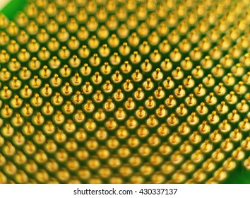 Closeup view of golden microprocessor pins. Abstract electronic technological background, focus is in the middle