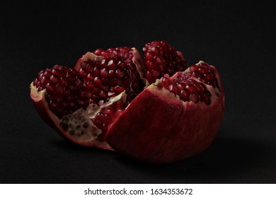 Closeup view of grain red grenades. Juicy ripe red pomegranates or pomegranates. Fruits of red ripe pomegranate on a studio background. Vegetarian concept, organic vitamins. Organic and healthy pomegr