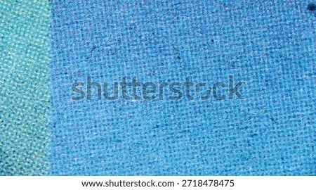 Close-up view of halftone pattern in cyan and blue ink on textured paper surface, revealing print dots.