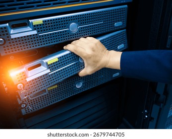 A close-up view of a hand adjusting a server within a data center. The image highlights the critical role of hardware maintenance in modern IT infrastructure.