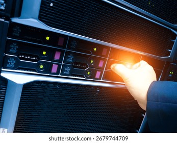 A close-up view of a hand operating a server in a data center, showcasing modern technology and the essential task of network management and maintenance.