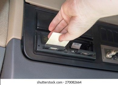 Closeup View Of A Hand Of Truck Driver Who Inserts  Tachograph Card To The Device Inside The Truck Cab.