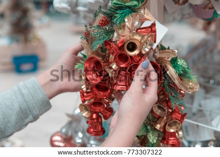 Closeup view of hands choosing Christmas tree or New Year's decoration bells. Holidays mood
