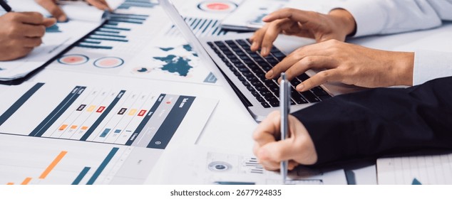Close-up view of hands engaged in collaborative business analysis with reports and charts, emphasizing teamwork and strategic planning in a modern office space. SACTR