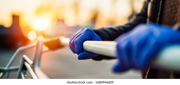 Close-up View Of Hands In Rubber Gloves Pushing Shopping Carts.