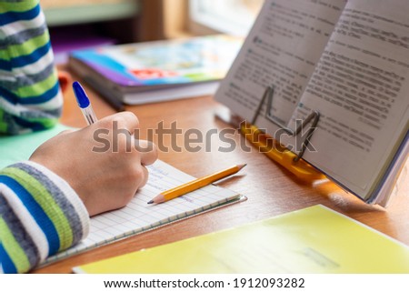 Close-up view of the hands of a schoolboy doing homework