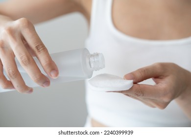 Close-up view hands of woman using toner and cotton pad to remove makeup - Shutterstock ID 2240399939
