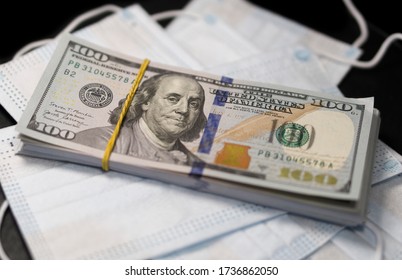 Closeup View Of Heap Of Dollar Bills With Medical Mask. Сoncept Of Making Money And Doing Business In The Context Of The Crisis Of A Coronavirus In The World