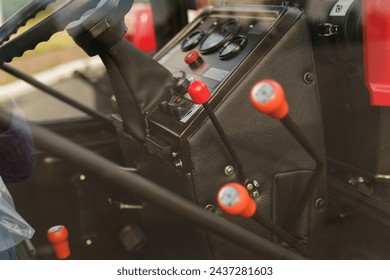 A close-up view highlighting the control levers inside the cabin of a tractor, showcasing the details of agricultural machinery.