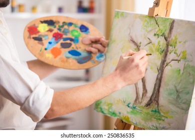 Close-up view of highly gifted painter while he is painting his picture. - Powered by Shutterstock