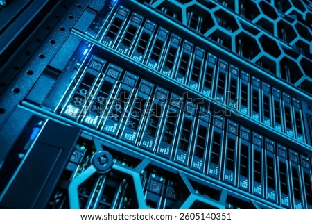 A close-up view of a high-tech server rack illuminated in blue light, showcasing advanced data storage technology in a modern data center environment.