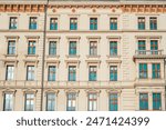 A close-up view of a historic building facade in Budapest, Hungary, showcasing its detailed stonework and arched windows. Perfect for travel and architecture photography.