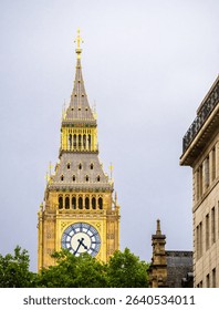 A close-up view of the iconic clock tower, Big Ben, in London, showcasing its intricate architecture and golden details against a cloudy sky.