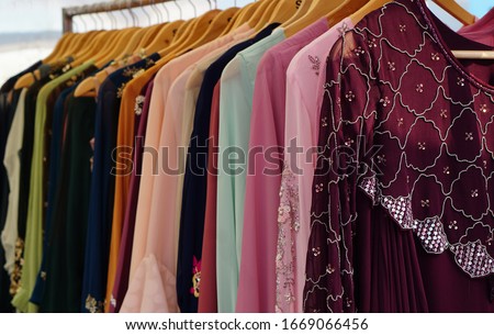  Closeup view of Indian woman fancy and fashion dress Hung on hangers in display of a retail shop                             